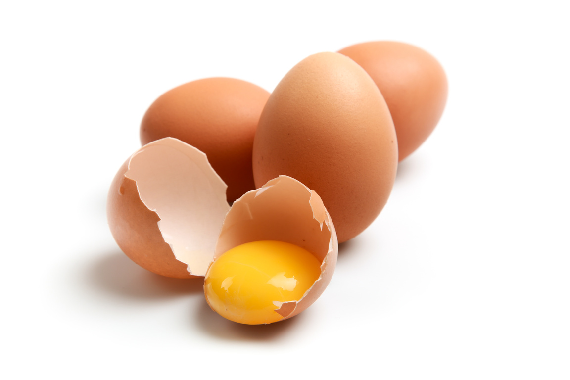 Eggs Next To Broken Egg With Yolk