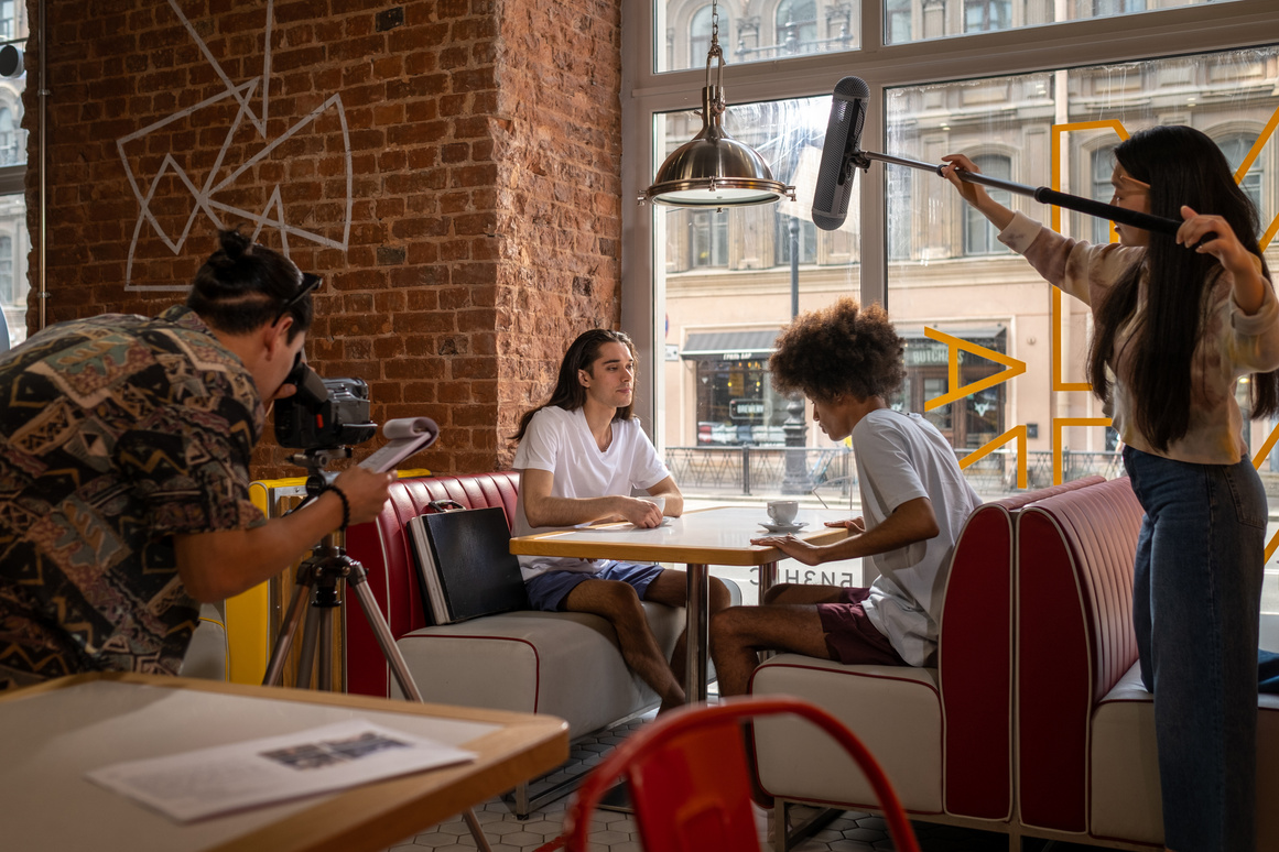 Group of young actors sitting in cafe 